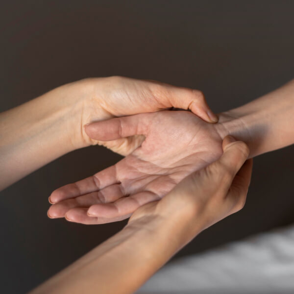 Une femme touche la main d'une autre personne, symbolisant l'importance de la rigueur pédagogique et scientifique.